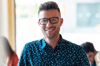 İş yerinde kameraya bakan yakışıklı, olgun girişimci fotoğrafı..