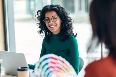 Birlikte çalışmak için yeni bir proje çizmek için renk paletindeki renkleri seçerken iki güzel tasarımcı kadının çekimleri.