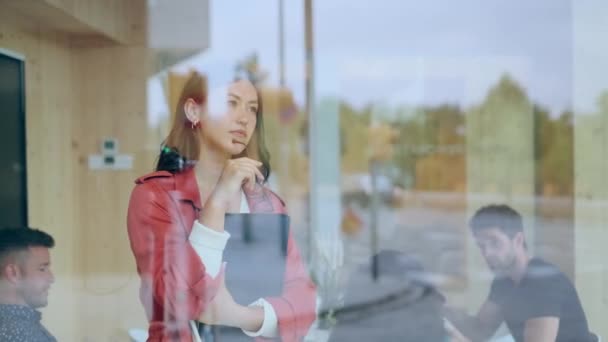 同僚の場所で窓の外を見ながら かなりビジネスマンの女性のビデオ — ストック動画