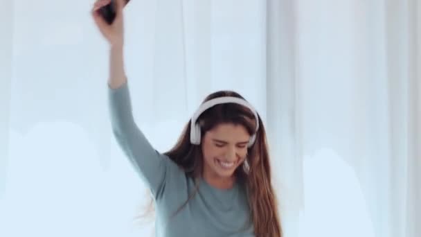 Vídeo Mulher Bonita Ouvindo Música Com Smartphone Enquanto Dança Sofá — Vídeo de Stock