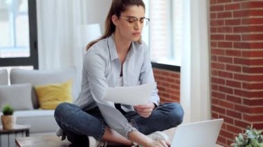 Akıllı iş kadınlarının evdeki oturma odasındaki masada otururken dizüstü bilgisayarla çalıştıkları video..