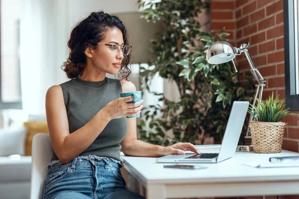 Evdeki Oturma Odasında Kahve Içerken Bilgisayarla Çalışan Güzel Bir Kadınının — Stok fotoğraf