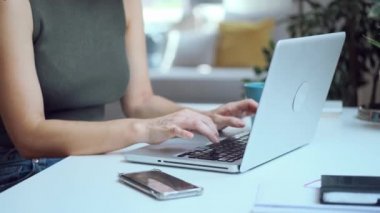 Evdeki oturma odasında dizüstü bilgisayarlı e-posta gönderirken çalışan güzel iş kadınının videosu..