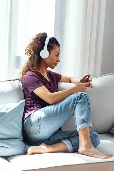 Tiro Jovem Confiante Ouvindo Música Com Smartphone Enquanto Sentado Sofá — Fotografia de Stock