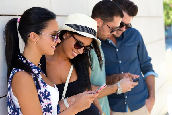 Retrato de grupo de amigos se divertindo com smartphones . — Fotografia de Stock