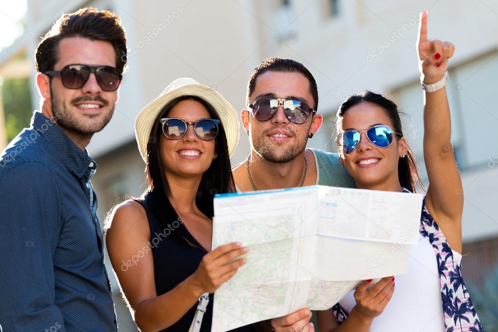 Group of friends use their map in the street.