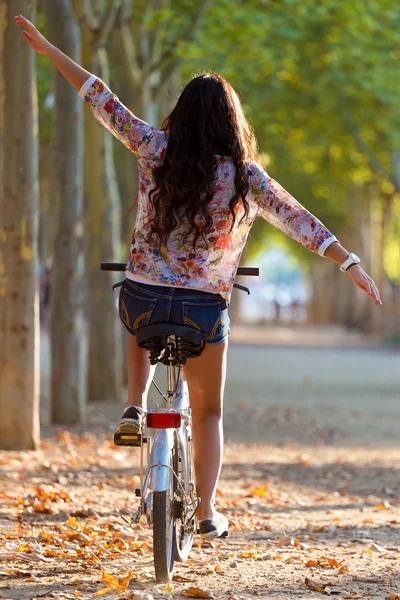 Jolie jeune fille à vélo dans une forêt . — Photo