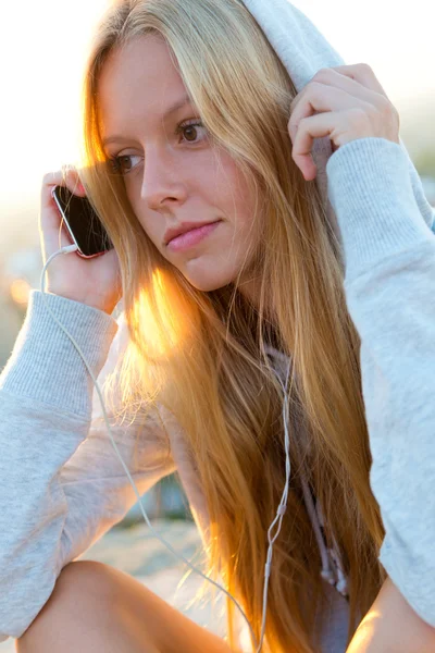 Hermosa chica sentada en el techo y escuchando música . —  Fotos de Stock