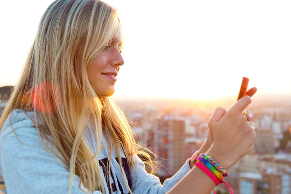 Prachtige blond meisje nemen van foto's van de stad. — Stockfoto