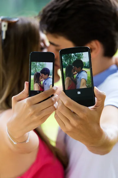 Pareja tomando fotos de sí mismos con el teléfono inteligente en romántico p — Foto de Stock