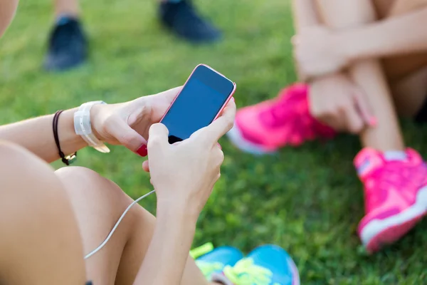 Chicas corriendo divirtiéndose en el parque con teléfono móvil . — Foto de Stock