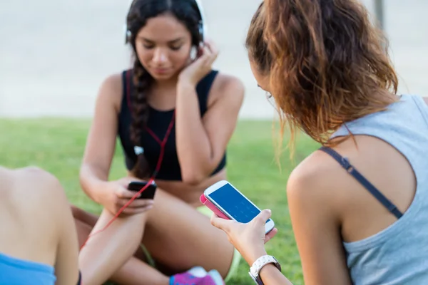 Running girls having fun in the park with mobile phone. — Stock Photo, Image