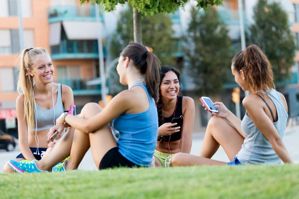 Running girls having fun in the park with mobile phone. — Stock Photo, Image