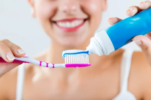 Hermosa joven mujer recogiendo sus dientes . —  Fotos de Stock