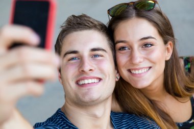Genç öğrenciler sokakta bir akıllı telefon ile fotoğraf çekmek.