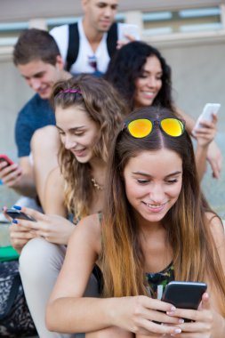 bir grup öğrencinin dersten sonra akıllı telefonlar ile eğleniyor.