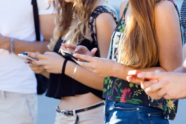 En grupp studenter ha kul med smartphones efter klass. — Stockfoto
