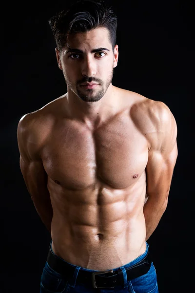 Beautiful and muscular man in dark background. — Stock Photo, Image