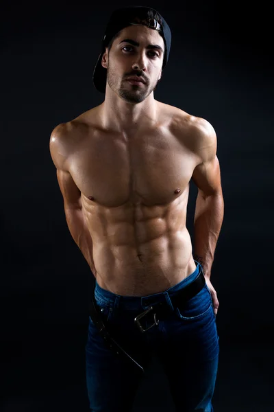 Beautiful and muscular man in dark background. — Stock Photo, Image