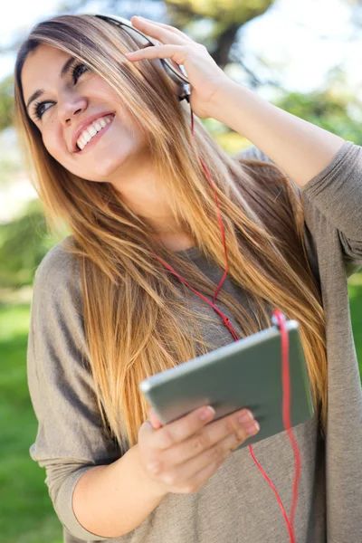 Portrait of beautiful girl listening to music with digital table — Stock Photo, Image