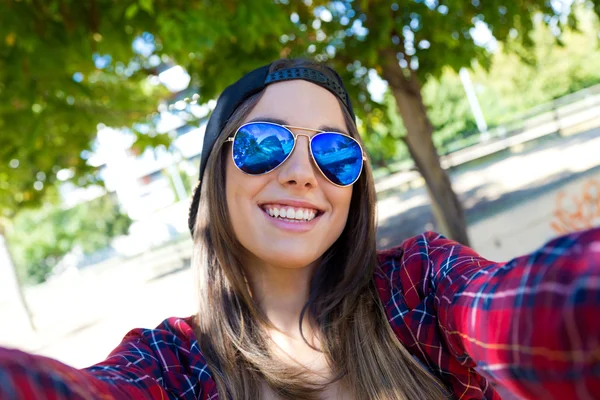 Outdoor Portret van mooie meisje dat een selfie met mobiele telefoon neemt in stad. — Stockfoto