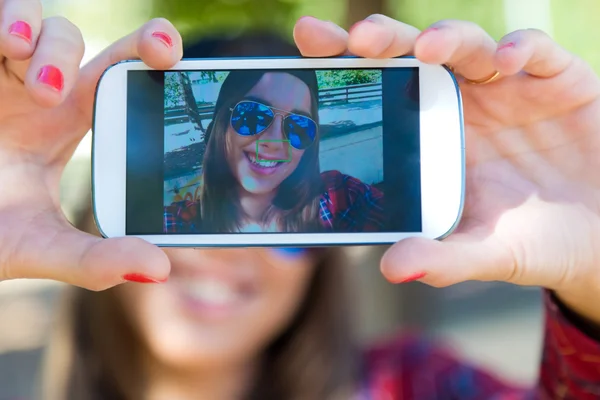 Retrato ao ar livre de menina bonita tirando uma selfie com telefone celular na cidade . — Fotografia de Stock