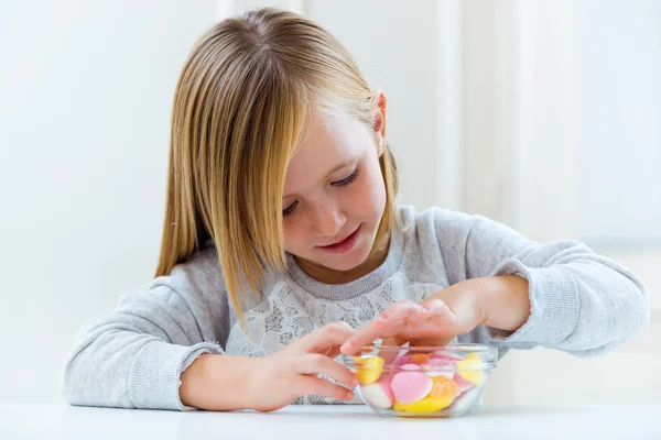 Linda criança comendo doces em casa . — Fotografia de Stock