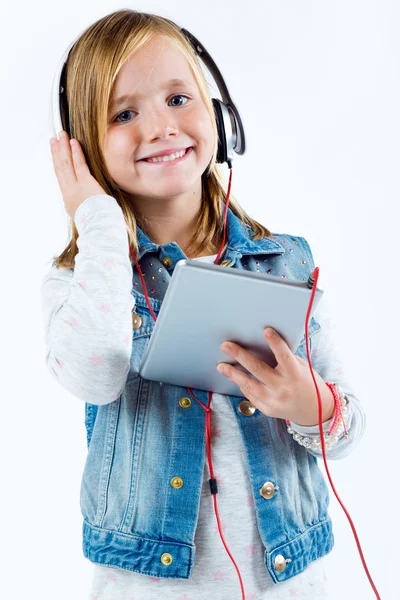 Belle enfant écoutant de la musique avec tablette numérique . — Photo