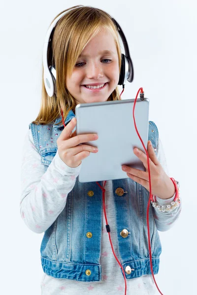 Belle enfant écoutant de la musique avec tablette numérique . — Photo