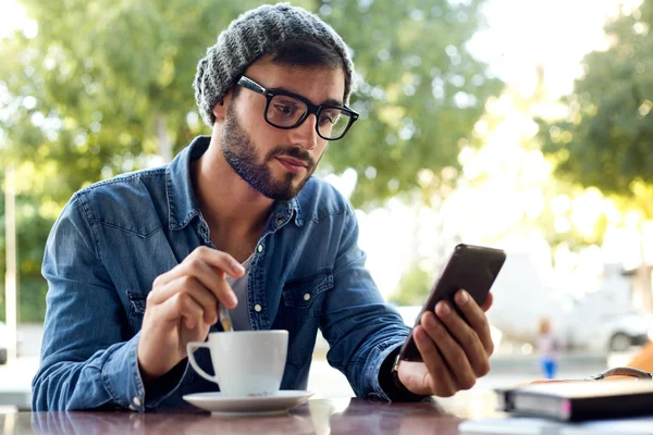 Moderne jongeman met mobiele telefoon in de straat. — Stockfoto