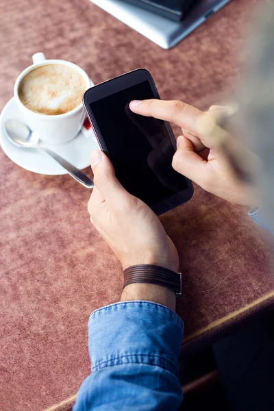 Moderne jongeman met mobiele telefoon in de straat. — Stockfoto