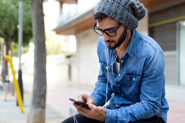 Moderne jongeman met mobiele telefoon in de straat. — Stockfoto