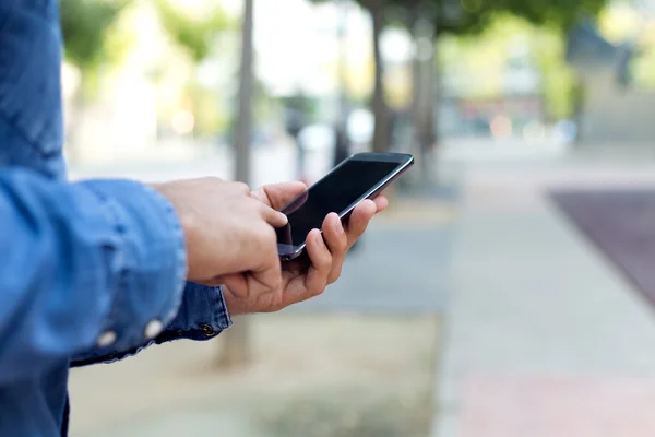 Modern ung man med mobiltelefon på gatan. — Stockfoto