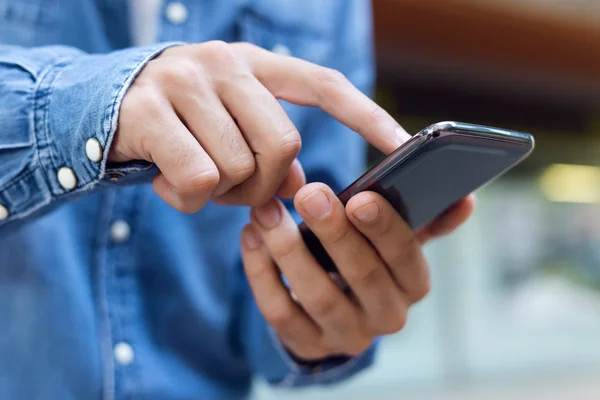 Moderno giovane uomo con telefono cellulare in strada. — Foto Stock