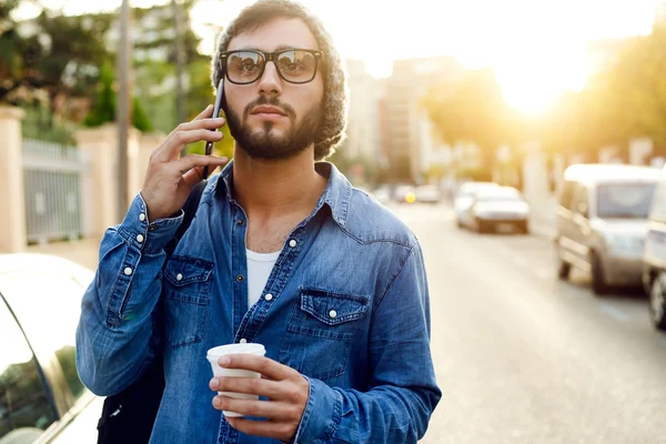 Moderne jongeman met mobiele telefoon in de straat. — Stockfoto