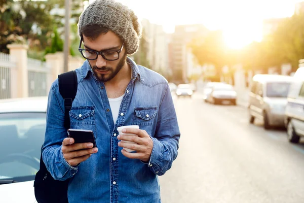 Moderner junger Mann mit Handy auf der Straße. — Stockfoto