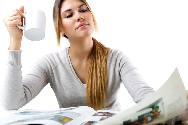 Young beautiful girl reading news and drinking coffee. Isolated — Stock Photo, Image