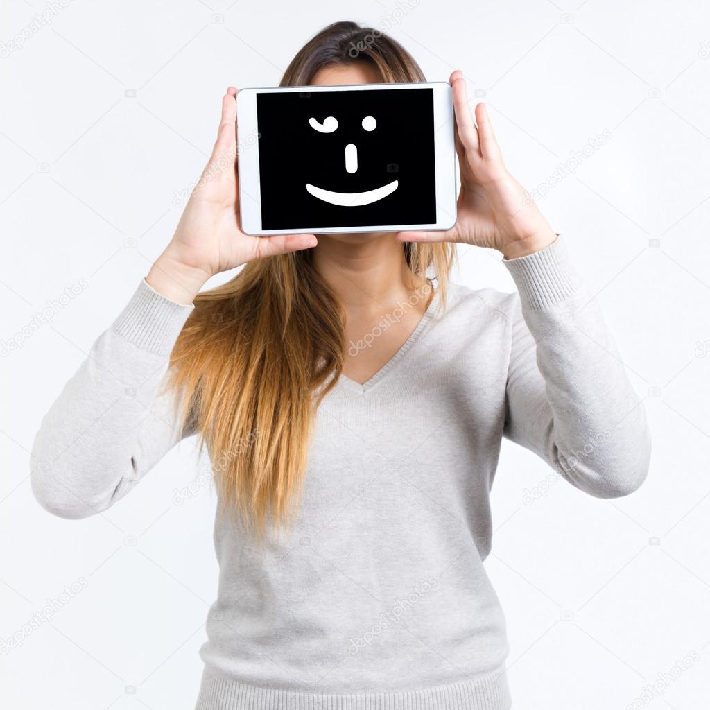 Young woman cover her face with digital tablet. Isolated on whit