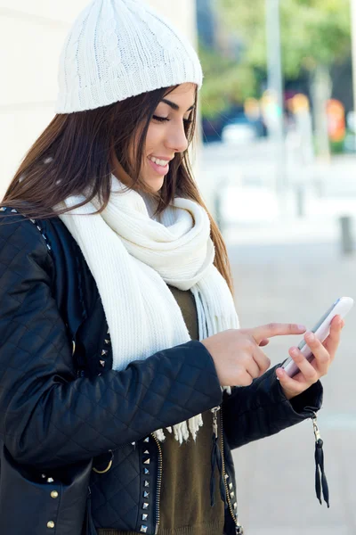 Belle fille utilisant son téléphone mobile en ville . — Photo