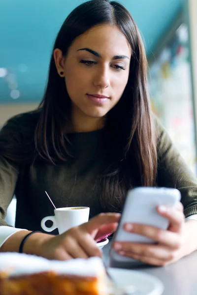 Menina bonita usando seu telefone celular no café . — Fotografia de Stock