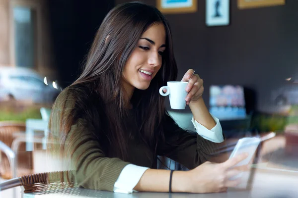 Mooi meisje met behulp van haar mobiele telefoon in café. — Stockfoto