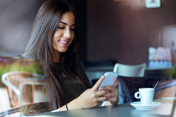 Menina bonita usando seu telefone celular no café . — Fotografia de Stock