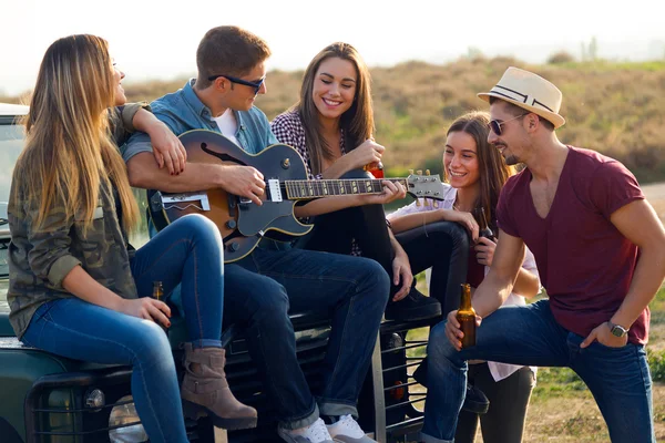 Portret van groep vrienden gitaarspelen en het drinken van bier. — Stockfoto