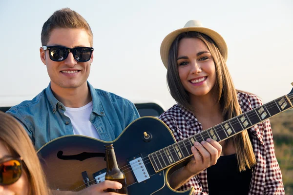 Ritratto di gruppo di amici che suonano la chitarra e bevono birra . — Foto Stock