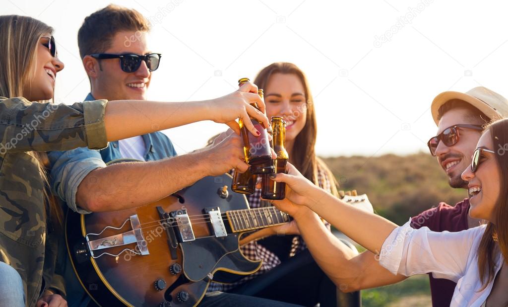 Portrait of group of friends toasting with bottles of beer.