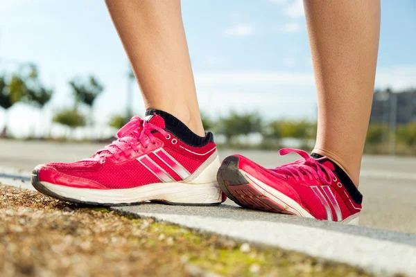 Runner voeten voorbereiding voor het uitvoeren van op weg close-up op schoen. — Stockfoto