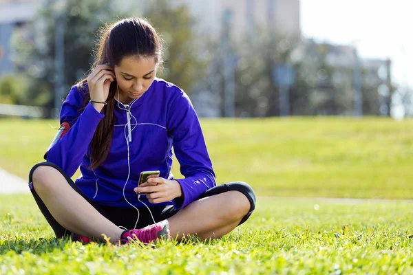 Pretty young woman listening to music after running. — Stock Photo, Image