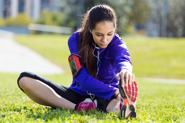 Ung kvinna stretching och förbereder för att köra — Stockfoto