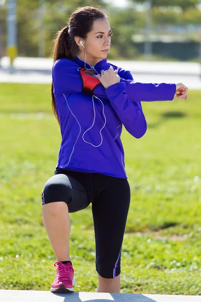 Jovem mulher se alongando e se preparando para correr — Fotografia de Stock