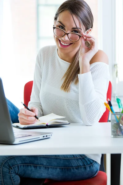 Pretty young woman working in her office. — Stock Photo, Image